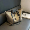 Simple casual Oxford shoulder bag with adjustable strap on sofa.