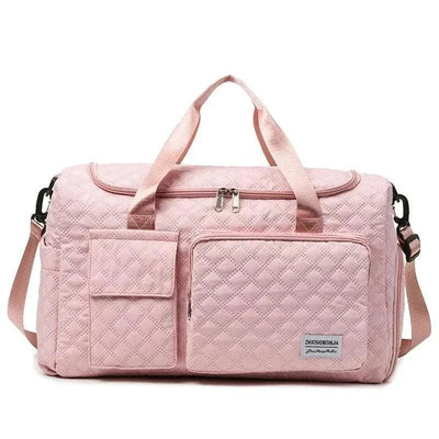 Fashion travel bag in pink canvas with large capacity and multiple compartments, featuring sturdy handles and adjustable shoulder strap.