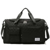 Large black canvas fashion travel bag with multiple compartments and adjustable strap.