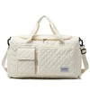 Fashion travel bag large capacity in cream canvas with multiple compartments and sturdy handles.